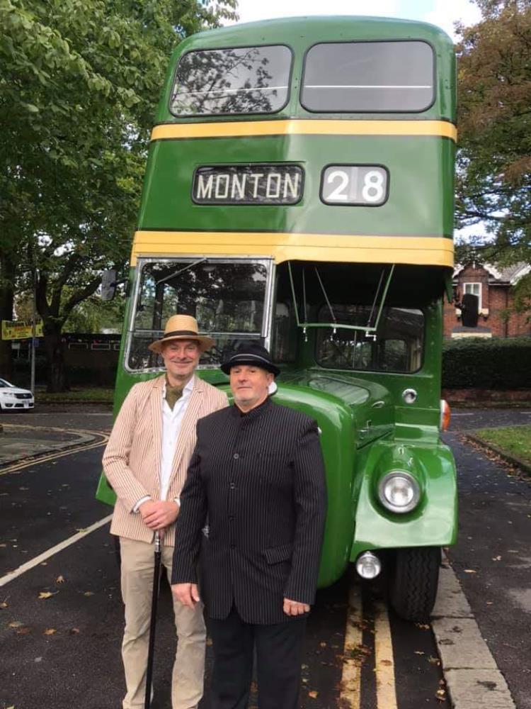Allan Grisdale and Darryl Brown standing next to an old fashioned green bus